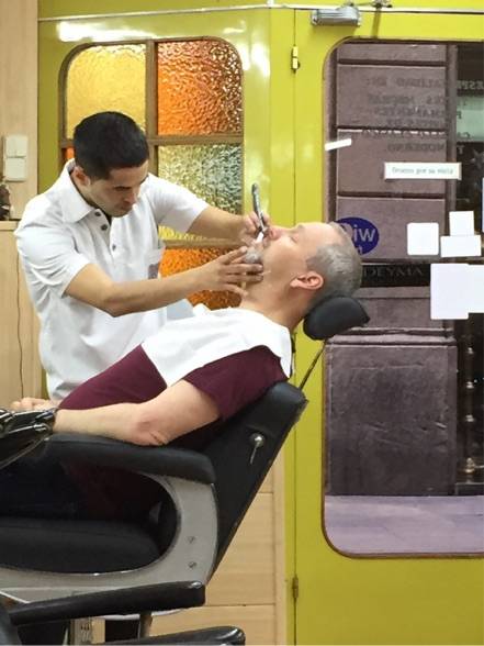 Image Title: Phil getting a close shave in #Barcelona, December 2015 {Photo: Open Door Travelers]