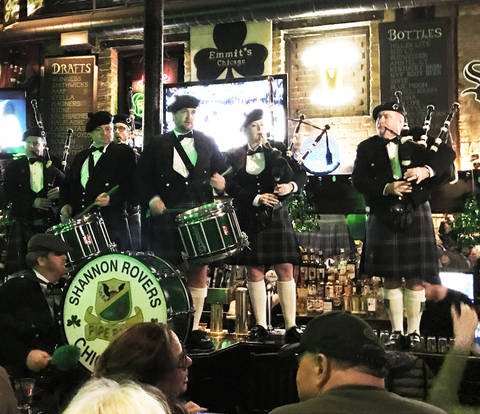 Image Title: The Shannon Rovers Bagpipers ON THE BAR at Emmit's Irish Pub in Chicago. [Photo: Open Door Travelers]