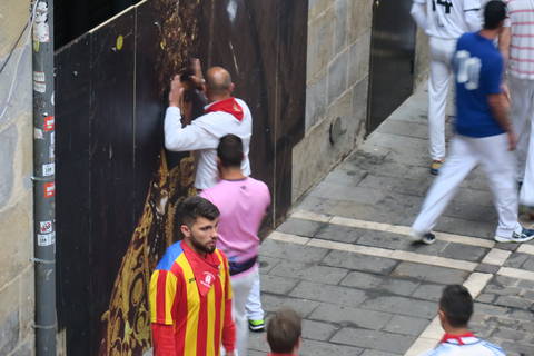 Image Title: Runners praying to San Fermin for a blessing before the run. [Photo: Open Door Travelers]